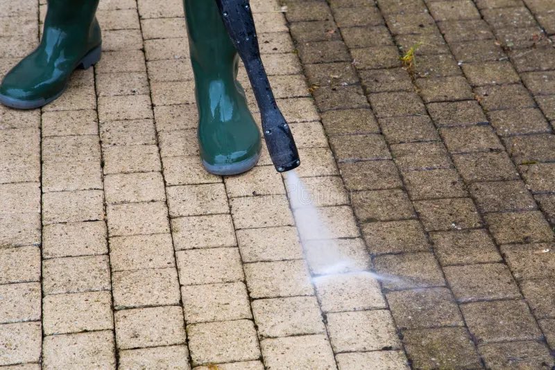 Power washing and exterior cleaning service on a paved walkway